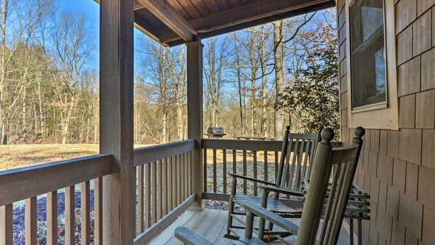 Eine Holzterrasse mit Sitzgelegenheiten und Blick auf einen Wald.