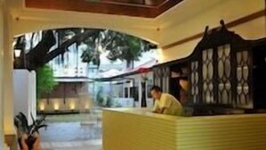 A reception area with a tiled floor, a reception desk, and a view of the outdoors. - The Yard Boutique Hotel (Kuala Lumpur)