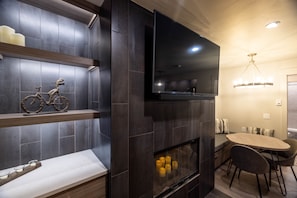 Cozy up by the fireplace and enjoy a meal at the dining table, complete with a flat-screen TV for entertainment.