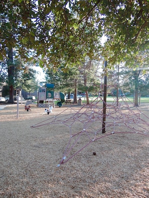 Children can climb and play on the rope structure in this park playground.
