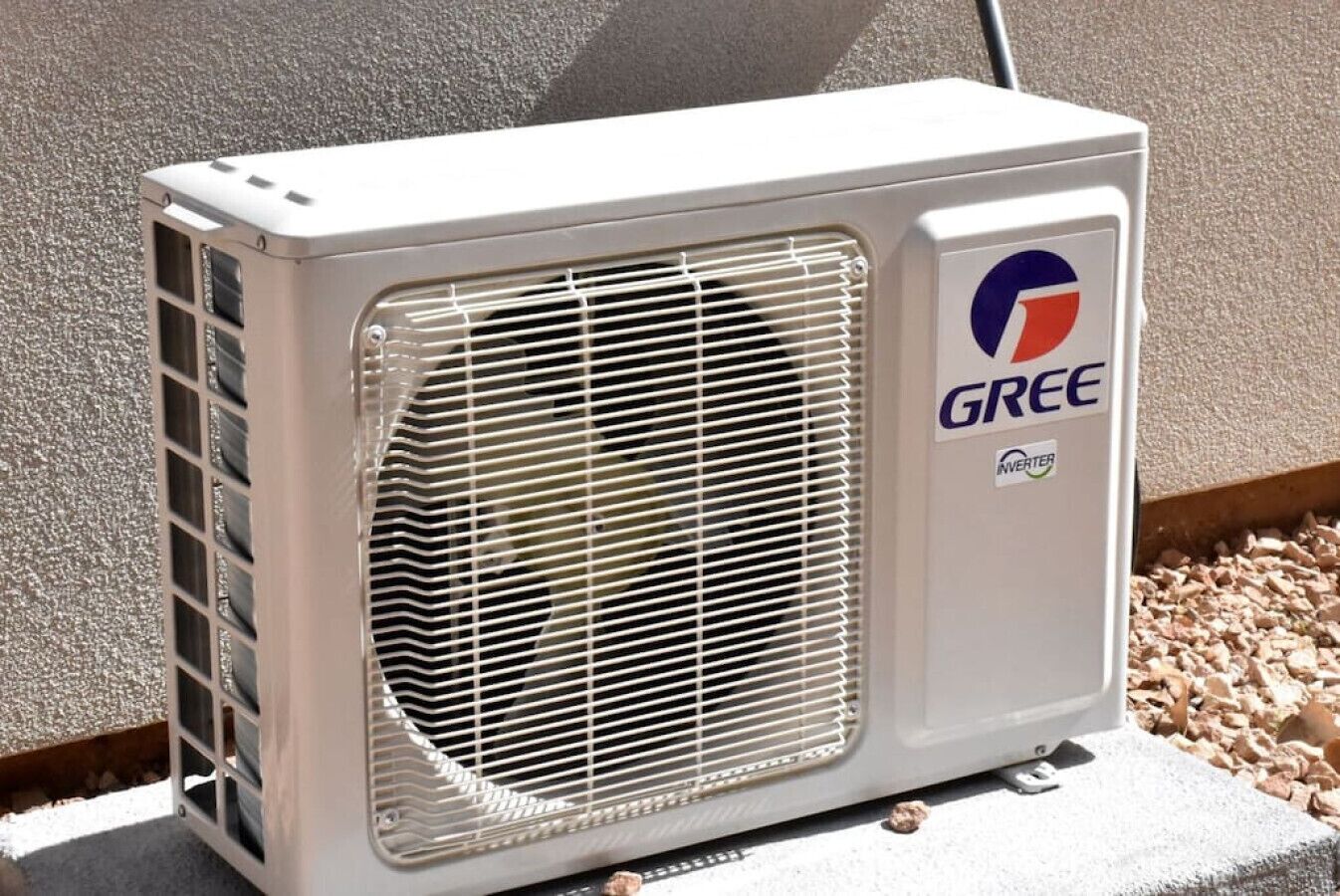 An outdoor air conditioning unit with a grille and a logo on the side.