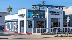 Una cafetería moderna llamada Better Buzz, con fachada de vidrio y mesas al aire libre.