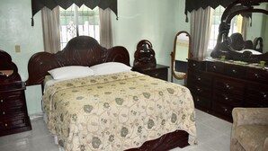 Une chambre à coucher avec un grand lit, une commode, un miroir et une chaise.