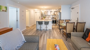 A modern apartment with a kitchen, dining area, and living room. - 4 Bedrooms Suite - Group of Families (Canmore)