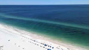 A beach with clear waters, a sandy shore, and several umbrellas. -  Check out specials for August/Fall stays  ! Spectacular views in newer complex! (Orange Beach)