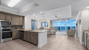 A modern kitchen with a large island, built-in appliances, and a view to the outside. -  Check out specials for August/Fall stays  ! Spectacular views in newer complex! (Orange Beach)