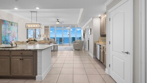 A spacious kitchen with a large island, a dining area with chairs, and a view to the outside. -  Check out specials for August/Fall stays  ! Spectacular views in newer complex! (Orange Beach)