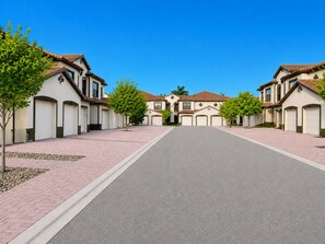 Een woonstraat met huizen, een heldere lucht en een verharde weg.
