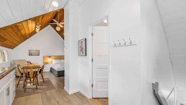 Una habitación acogedora y bien iluminada, con comedor, cama y ventilador de techo.