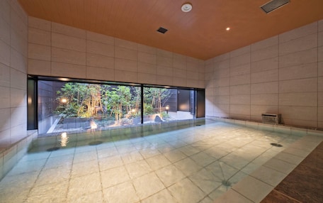 A spacious indoor area with a large window, a tiled floor, and a small water feature.