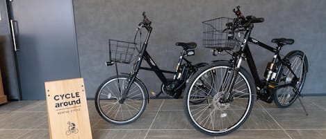 Two bicycles with baskets, a 'CYCLE around' sign, and a 'PRIVATE' door in the background.