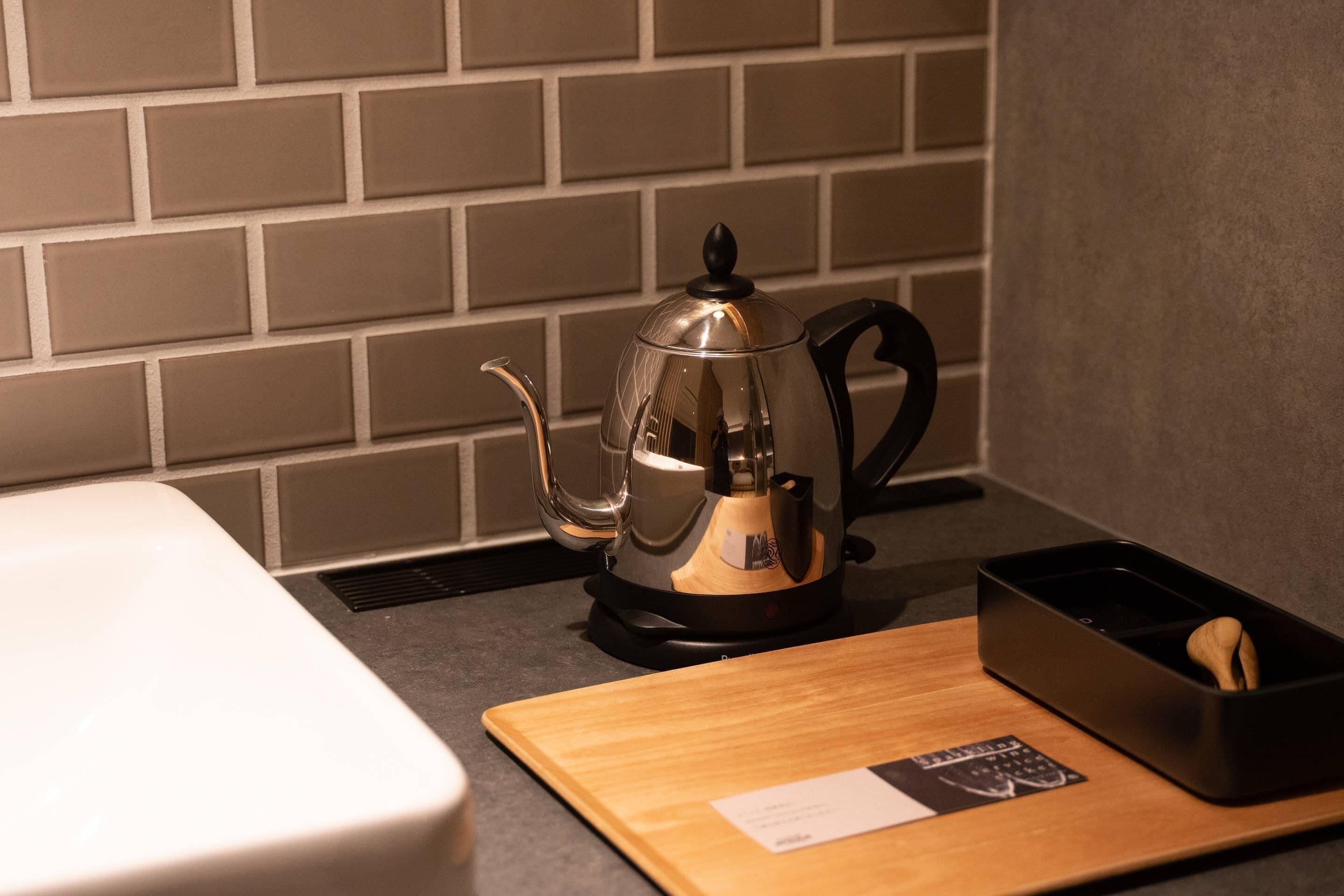 A kitchen with a coffee maker, a wooden cutting board, and a black tray with a spoon.
