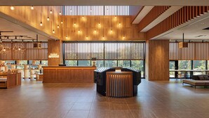 A modern hotel lobby with wooden paneling, a reception desk, and a seating area. - hotel around TAKAYAMA, an Ascend Collection Hotel (Takayama)