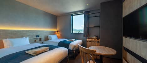 A hotel room with two beds, a dining table, a TV, and a window with a view.