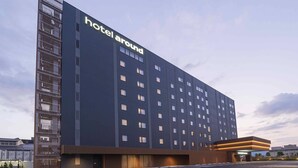 A modern hotel building with a prominent 'hotel around' sign, a parking lot, and a gated entrance. - hotel around TAKAYAMA, an Ascend Collection Hotel (Takayama)