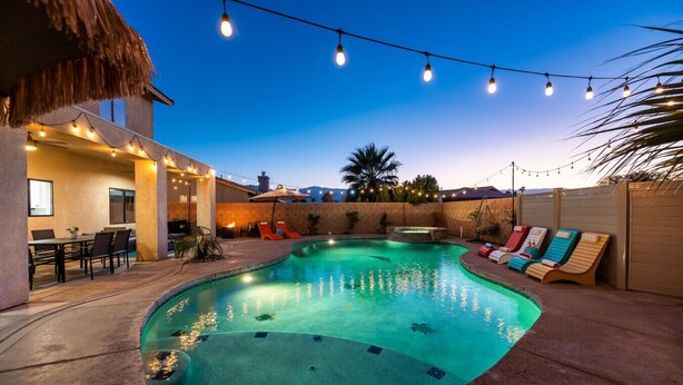 A swimming pool with a hot tub, outdoor seating, and string lights. - The Desert Hideaway | Game Room, Pool & Outdoor Kitchen [Free Spa Heating + Early Check-In] (Indio)