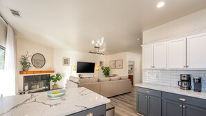 A modern kitchen with dark cabinets, a marble countertop, and a built-in oven. - The Desert Hideaway | Game Room, Pool & Outdoor Kitchen [Free Spa Heating + Early Check-In] (Indio)