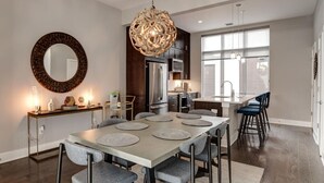 A modern kitchen with dark wood cabinets, stainless steel appliances, and a large window providing natural light. - South Slope Skyhaus with Rooftop Terrace (Asheville)