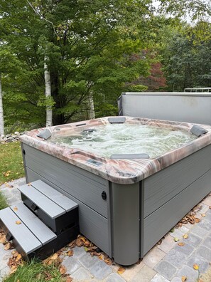 A hot tub with a marble-like exterior, a control panel, and a wooden bench. - Serene mountain escape with beautiful views and a hot tub (Jefferson)