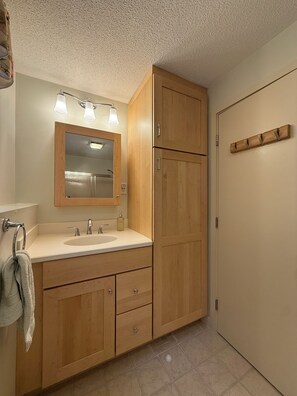 A bathroom with a wooden vanity, a sink, a mirror, and a towel rack. - Serene mountain escape with beautiful views and a hot tub (Jefferson)