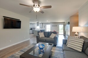 Relax in this stylish living room with a flat-screen TV, sofa, and coffee table.