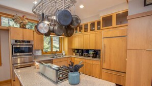 Una cocina moderna con electrodomésticos de acero inoxidable, armarios de madera y encimera de granito.