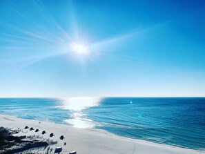 Una spiaggia con cielo sereno e il sole splendente.