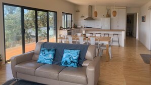 Una sala de estar moderna con un sofá y un comedor con una cocina al fondo.