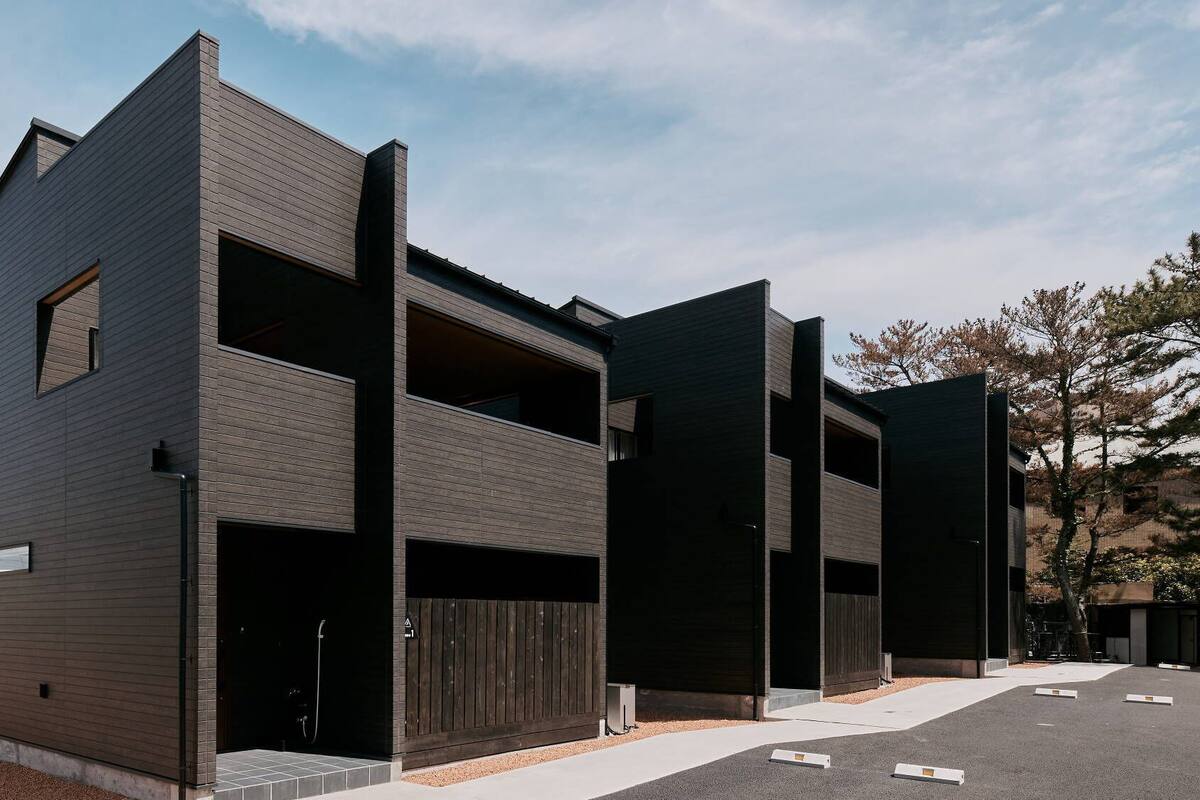 Een modern gebouw met twee verdiepingen, een plat dak, grote ramen en een garage-ingang.