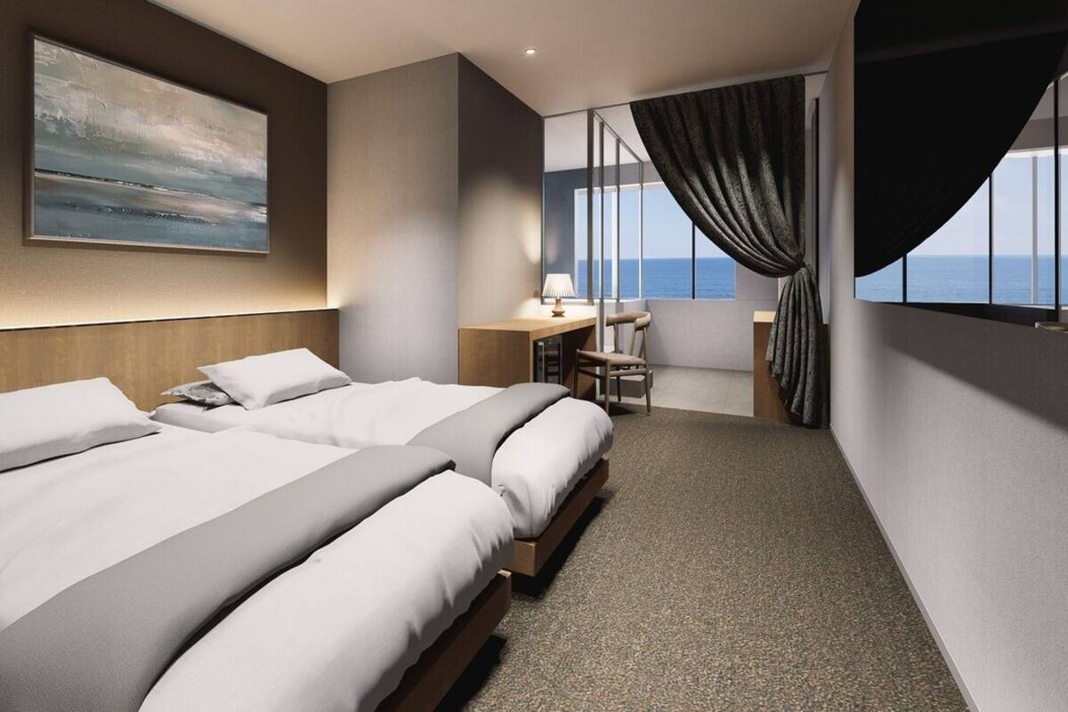 Een hotelkamer met twee bedden, een bureau, een stoel en een groot raam met gordijnen.