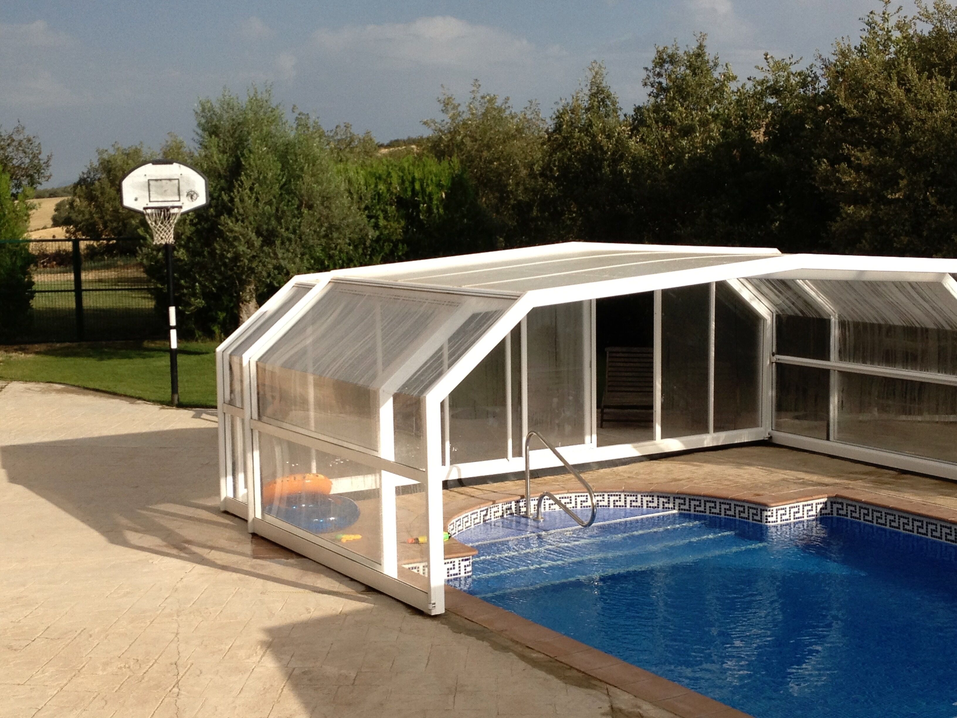 Une piscine dotée d’un espace jacuzzi fermé par des parois de verre.
