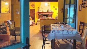 Een eetgedeelte met een tafel voor vier personen, een open haard en uitzicht op de keuken.