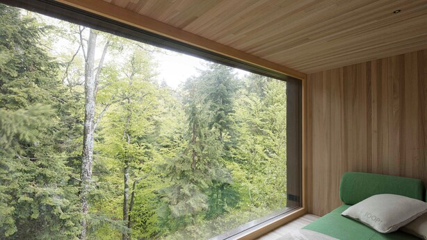 A bedroom with a large window, a bed with green bedding, and a view of a forest. - Adventure tree house, Baldauf family - Tree house (Sulzberg)