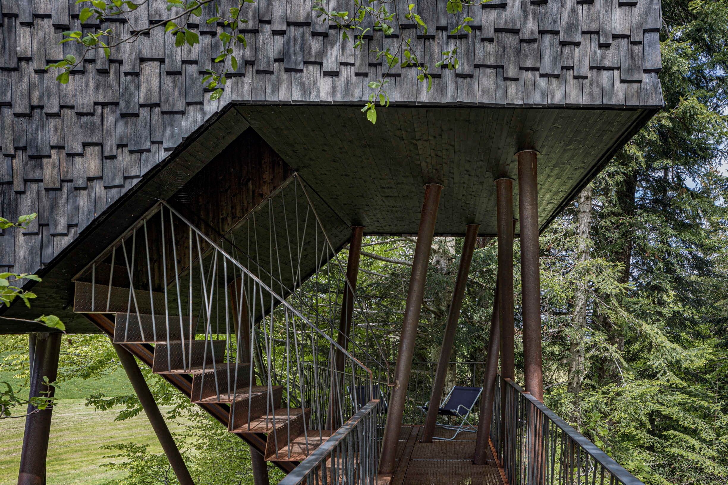 A wooden structure with a staircase and a chair.