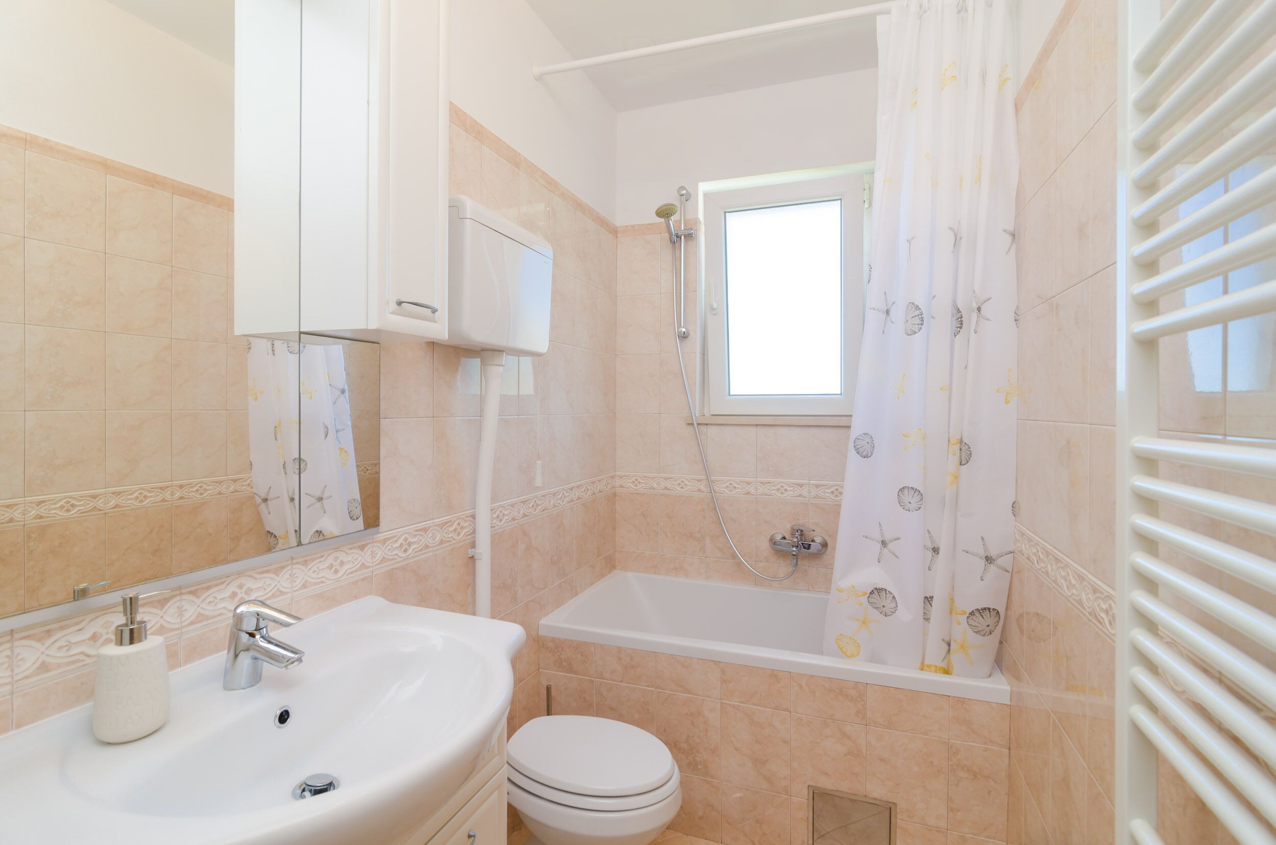 A bathroom with a sink, toilet, and bathtub.