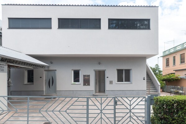 Un edificio moderno con tetto piano, tre finestre e una porta.