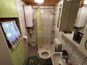 A compact bathroom with a toilet, bidet, and sink.