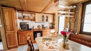Eine Holzküche mit Kreidetafel, Holzschränken und einem Esstisch mit Unterlage.