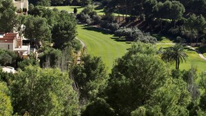 A coastal view with a golf course, dense trees, and buildings in the foreground. - Spacious duplex, beautiful view of the golf course and sea. 120 m2. 5 mn from the beach  (Altea)