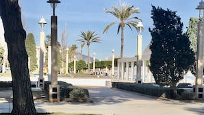 A park with palm trees, lamp posts, and a paved walkway. - Spacious duplex, beautiful view of the golf course and sea. 120 m2. 5 mn from the beach  (Altea)