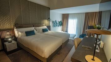 Een moderne hotelkamer met een groot bed, een bureau en een zithoek.