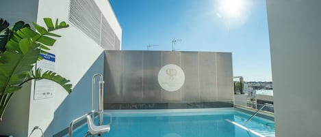 Een seizoensgebonden buitenzwembad, parasols voor strand/zwembad