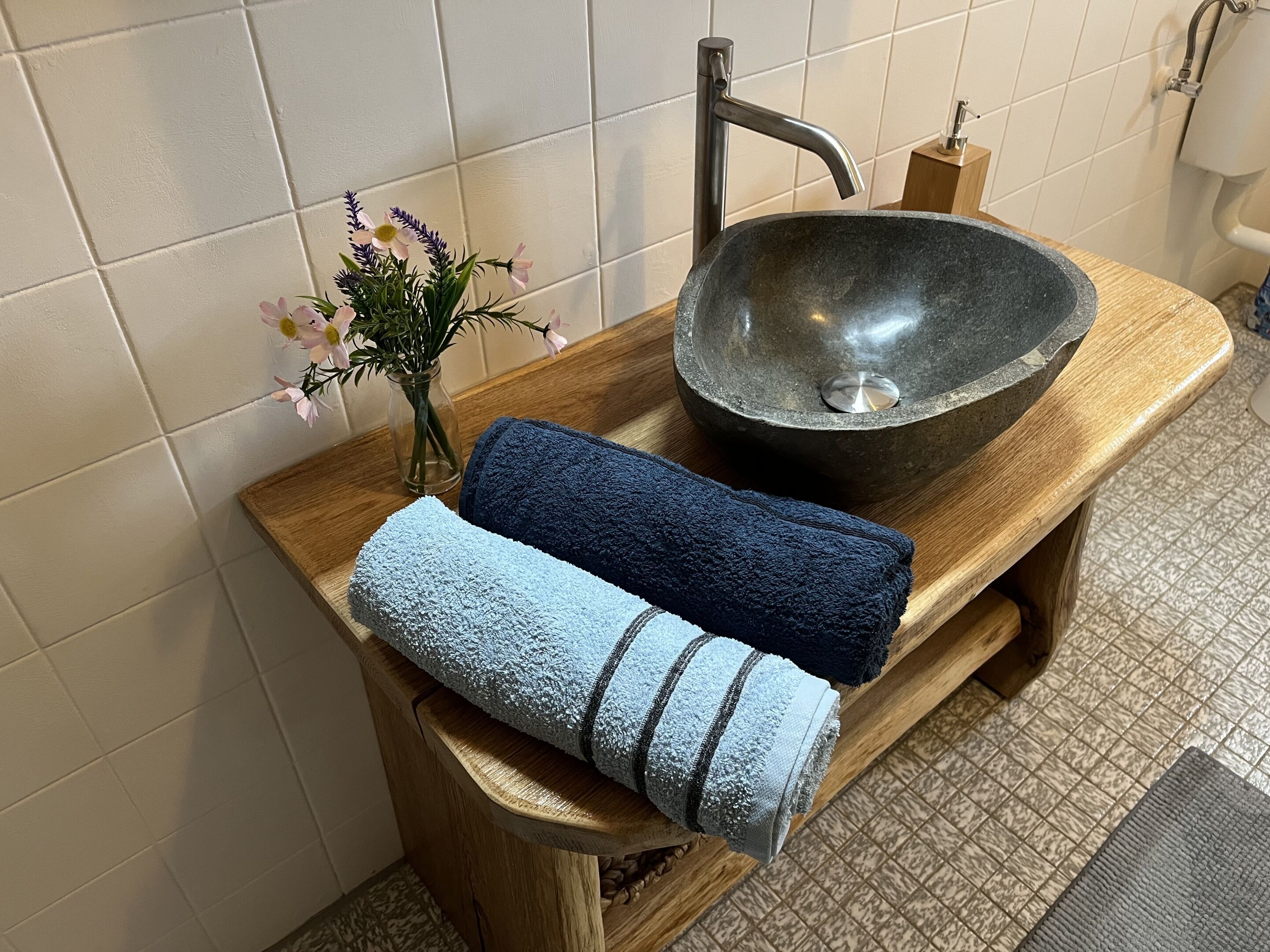 Ein Badezimmer mit einem Steintonne, einer Holzauskładung und Handtüchern.