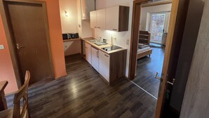 Une cuisine compacte avec des meubles en bois, un four à micro-ondes encastré et un évier.