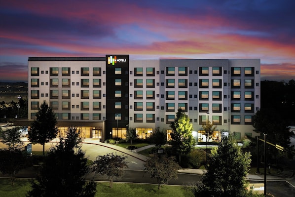 Monikerroksinen hotelli, jossa on moderni muotoilu ja jonka julkisivussa on suuri, huomiota herättävä ”HOTEL”-kyltti.