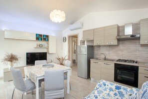 A modern kitchen with a built-in oven, a refrigerator, and a gas stove. - Idyllic Holiday Home "Oasis of Relaxation" with Garden and Terrace (Budoni)