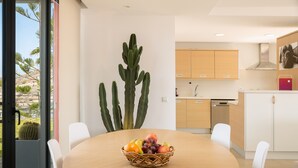 A dining area with a round table, a fruit basket, and a cactus plant. - Las Terrazas Villa 3 with Sea View, Wi-Fi, Pool, Garden & Terraces (El Salobre)
