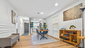 A modern living room with a dining area, wooden flooring, and a bookshelf. - Energy Villa 1-Sleeps 4 (Atlanta)