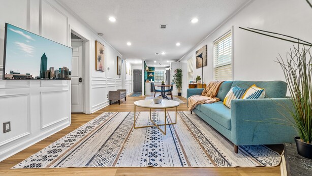 A modern living room with a blue sofa, a round coffee table, and a patterned rug. - Energy Villa 1-Sleeps 4 (Atlanta)