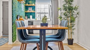 A dining area with a wooden table and two blue upholstered chairs. - Energy Villa 1-Sleeps 4 (Atlanta)
